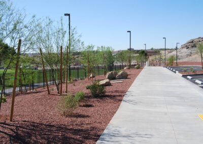 sidewalk and landscaping with new shrubs and trees with decorative rock at lone mountain park for horse riding